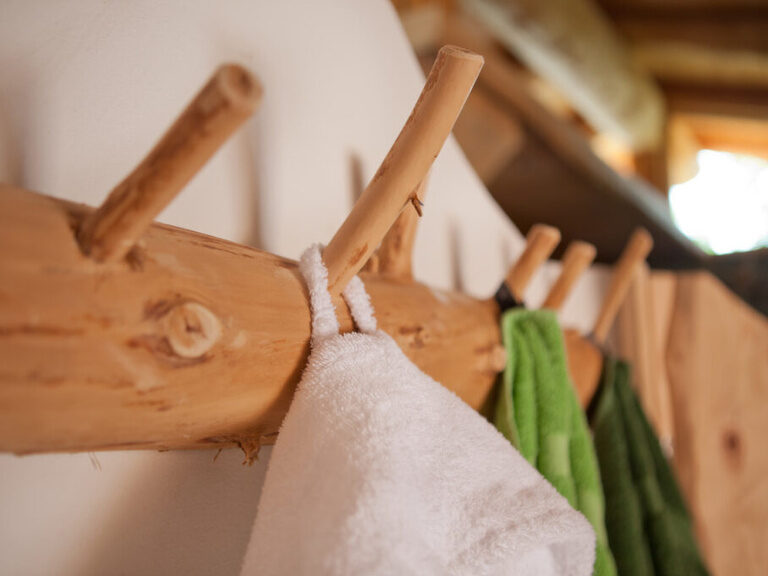 Weiße Bademäntel hängen an einem Aufhänger im Wellnessbereich des Hotel Konradshof im Nordschwarzwald