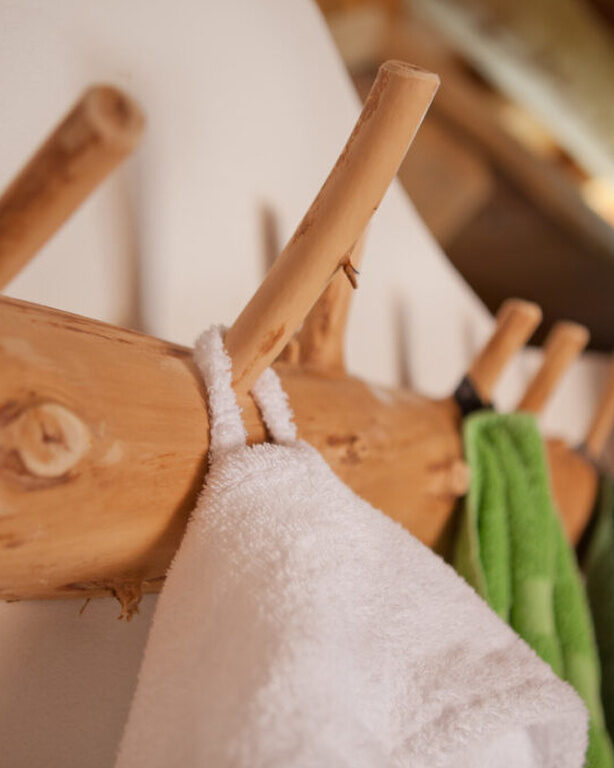 Weiße Bademäntel hängen an einem Aufhänger im Wellnessbereich des Hotel Konradshof im Nordschwarzwald