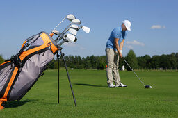 Mann beim Abschlag auf einem Golfplatz