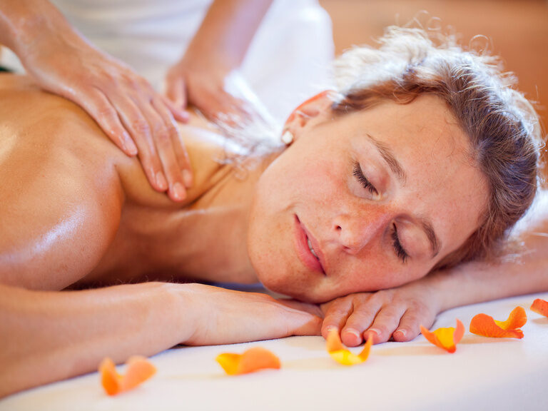 Entspannte Frau bei einer wohltuenden Rückenmassage im Wellnessbereich des Hotel Konradshof im Nordschwarzwald