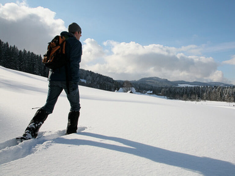 Ein Mann mit Schneeschuhen im Schnee beim Winterwandern
